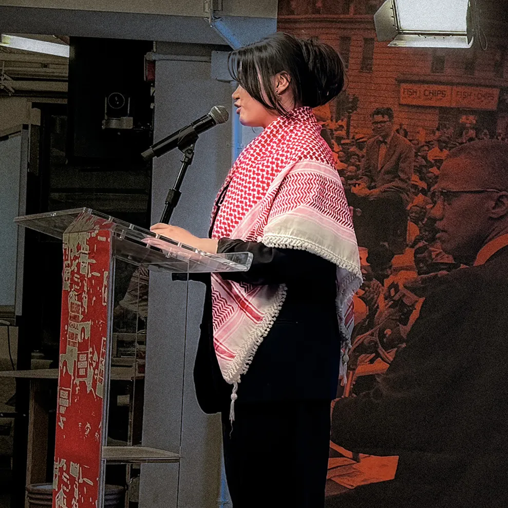 Person standing and speaking at a podium.